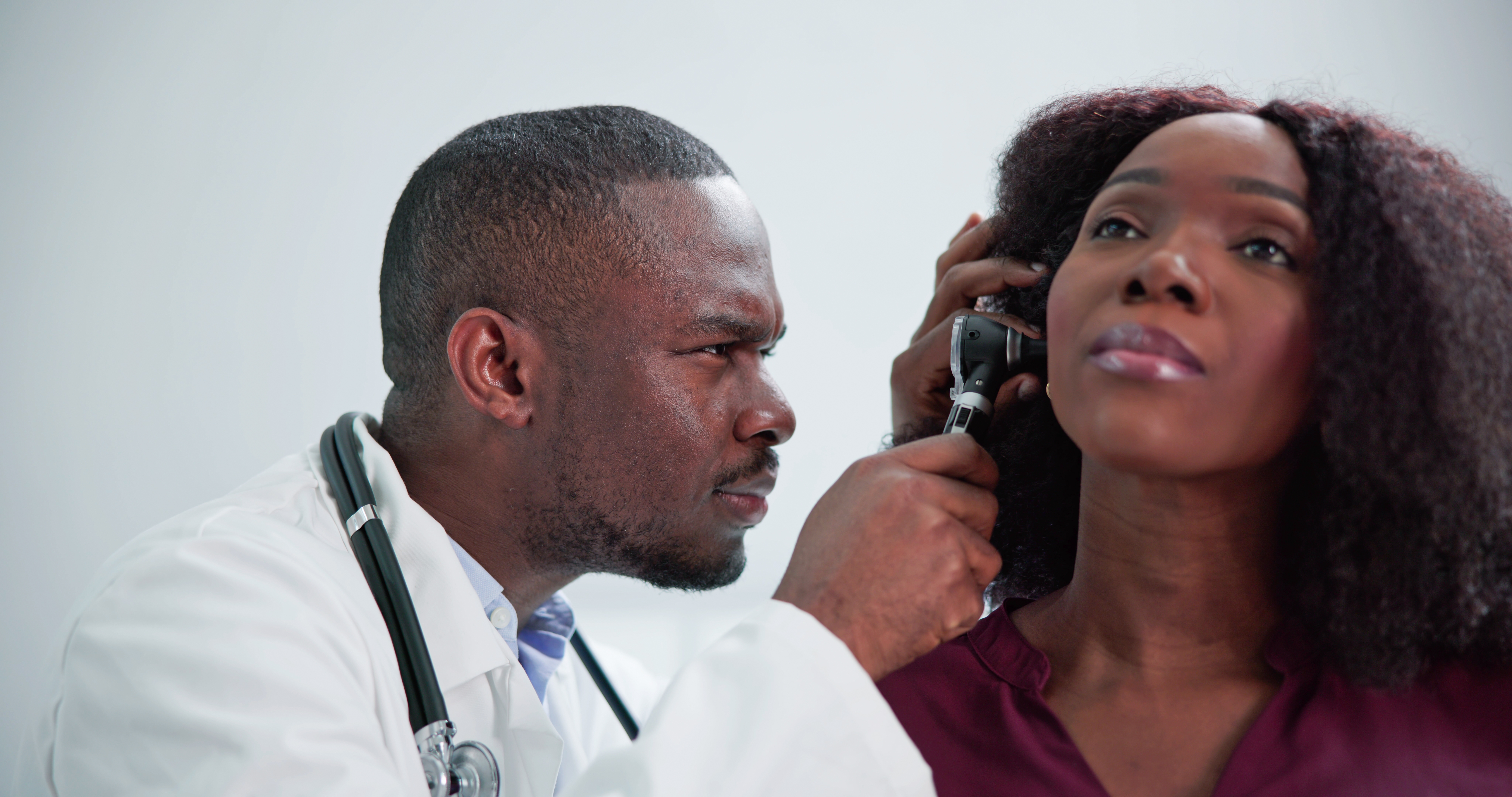 Audiologist looking at a client's ear