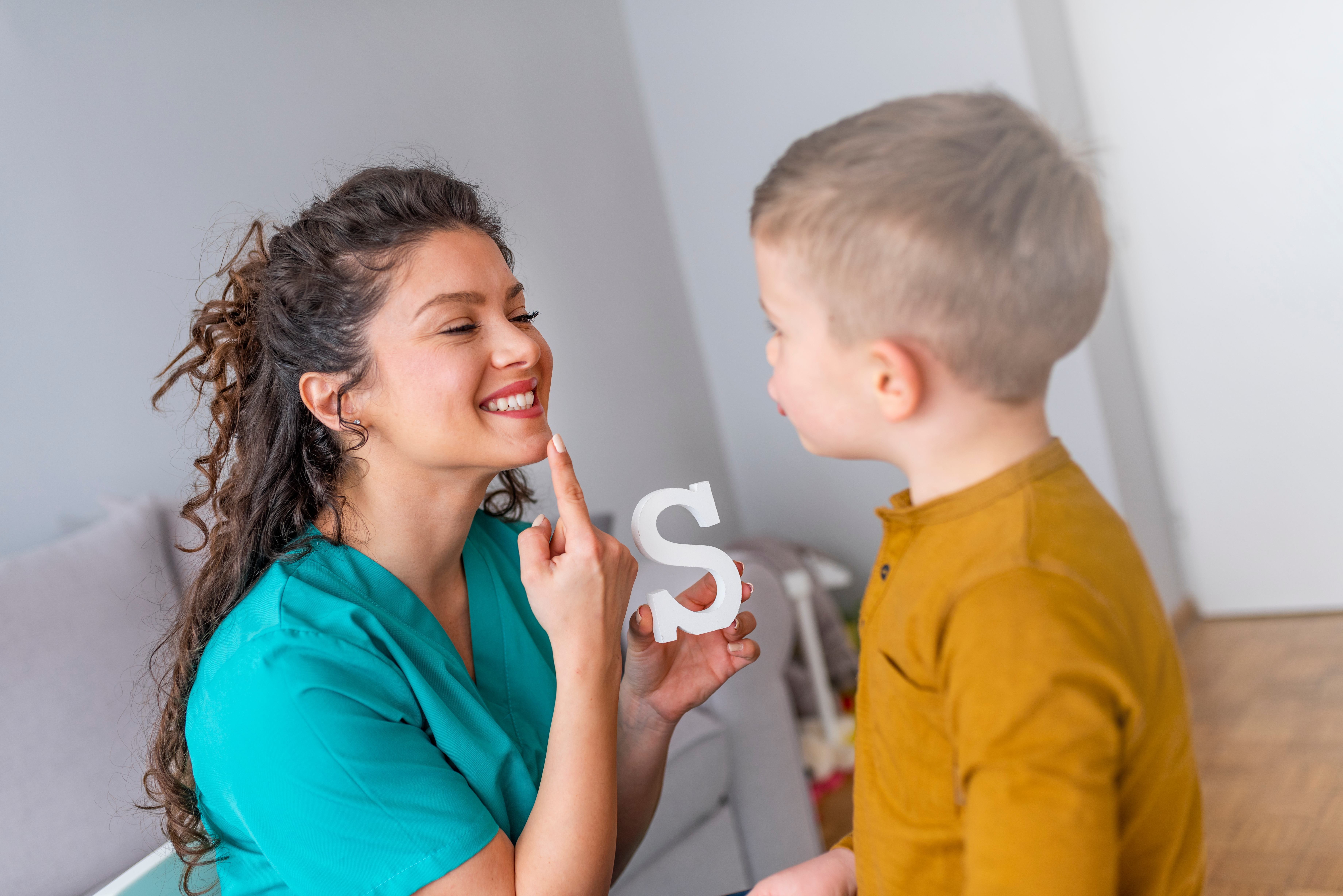 Image of a communication disorders technician working on speech therapy with a child