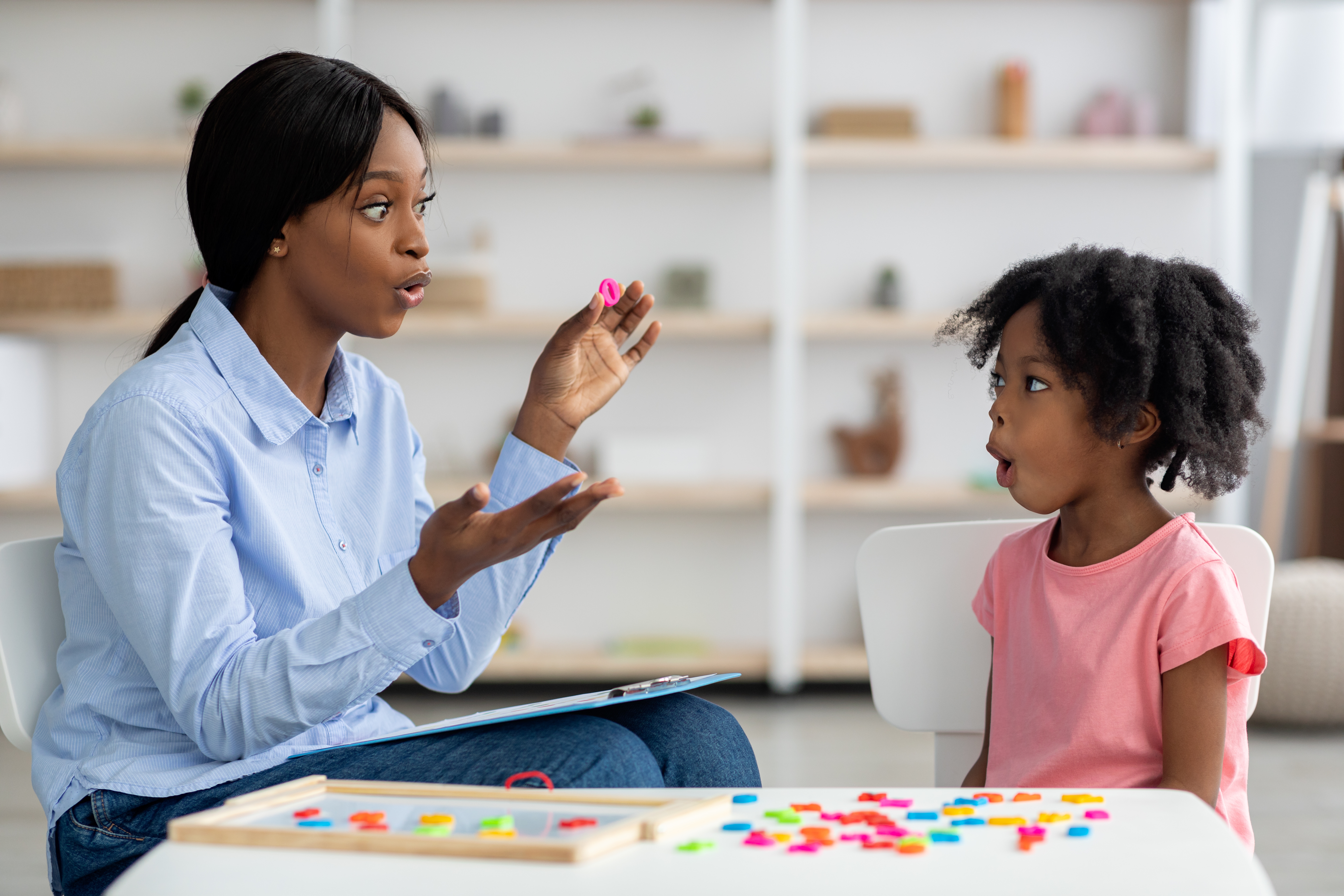 Image of a speech-language pathologist working on speech therapy with a child